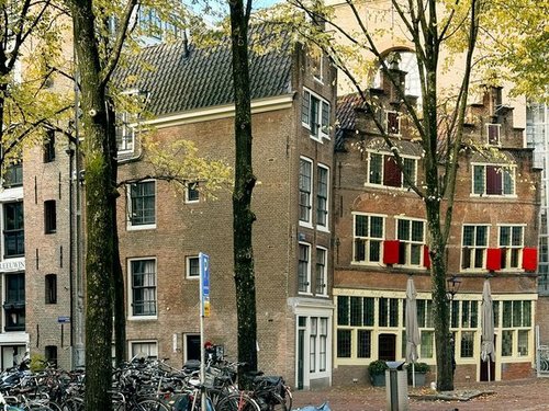 Geparkte Fahrräder in einer herbstlichen Gasse in Amsterdam. 