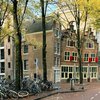 Geparkte Fahrräder in einer herbstlichen Gasse in Amsterdam.