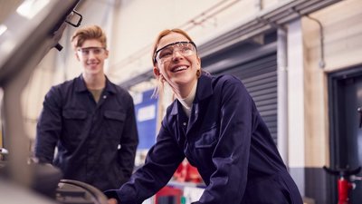 Zwei junge Lehrlinge in einer Autowerkstatt.