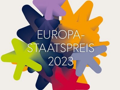 Bunte Sterne ineinader verlaufend vor grauem Hintergrund mit Aufschrift Europasstaatspreis 2023 im Vordergrund