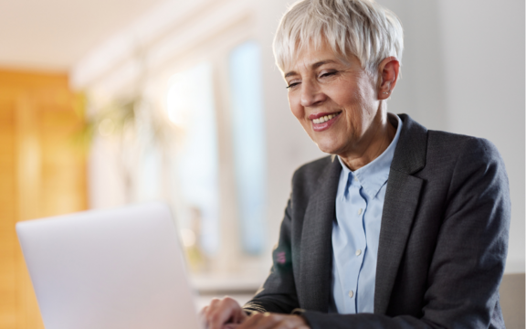 Lachende Frau vor einem Laptop