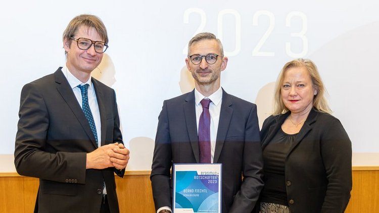 Mann hält eine Urkunde in der Hand