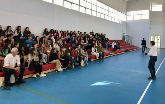 Menschengruppe bei Vortrag in einer Turnhalle