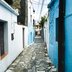 Blick auf eine kleine Gasse mit blauen Häusern.