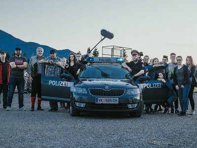 Schülerinnen und Schüler bei den Dreharbeiten vor einem Polizeiauto mit dem Kennzeichen "VK"