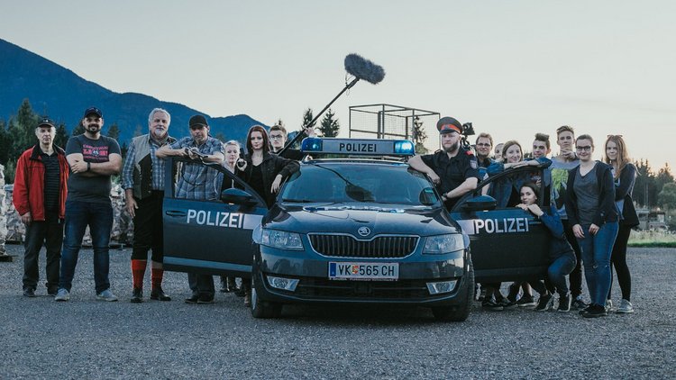 Schülerinnen und Schüler bei den Dreharbeiten vor einem Polizeiauto mit dem Kennzeichen "VK"