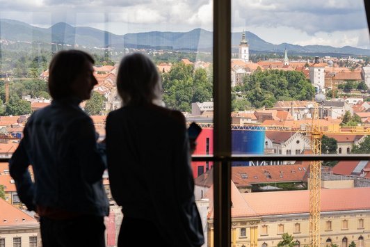 Zwei Personen auf einer Konferenz blicken über die Stadt