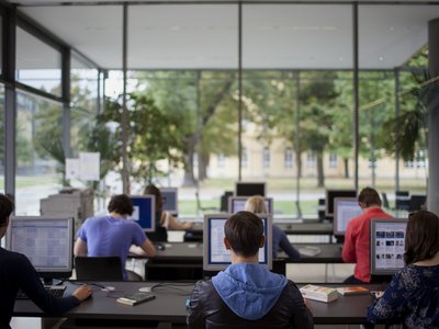 Klassenraum mit Schülern vor Bildschirmen