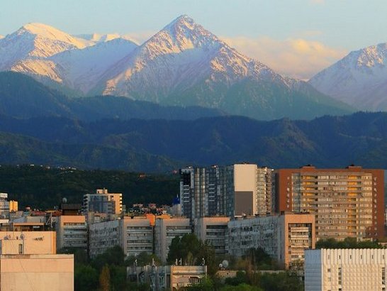 Blick auf die Stadt Almaty mit Berggipfeln im Hintergrund.