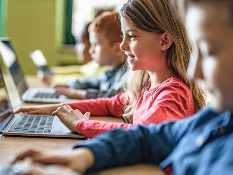 Schulkinder vor Laptops